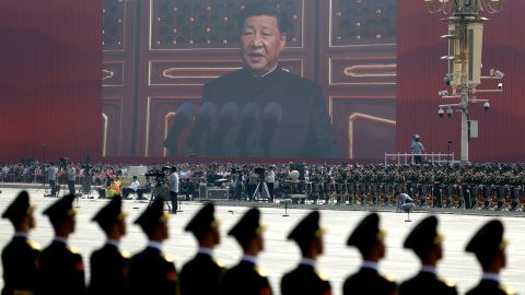 A screen shows Chinese President Xi Jinping delivering a speech at the start of the parade in Beijing.