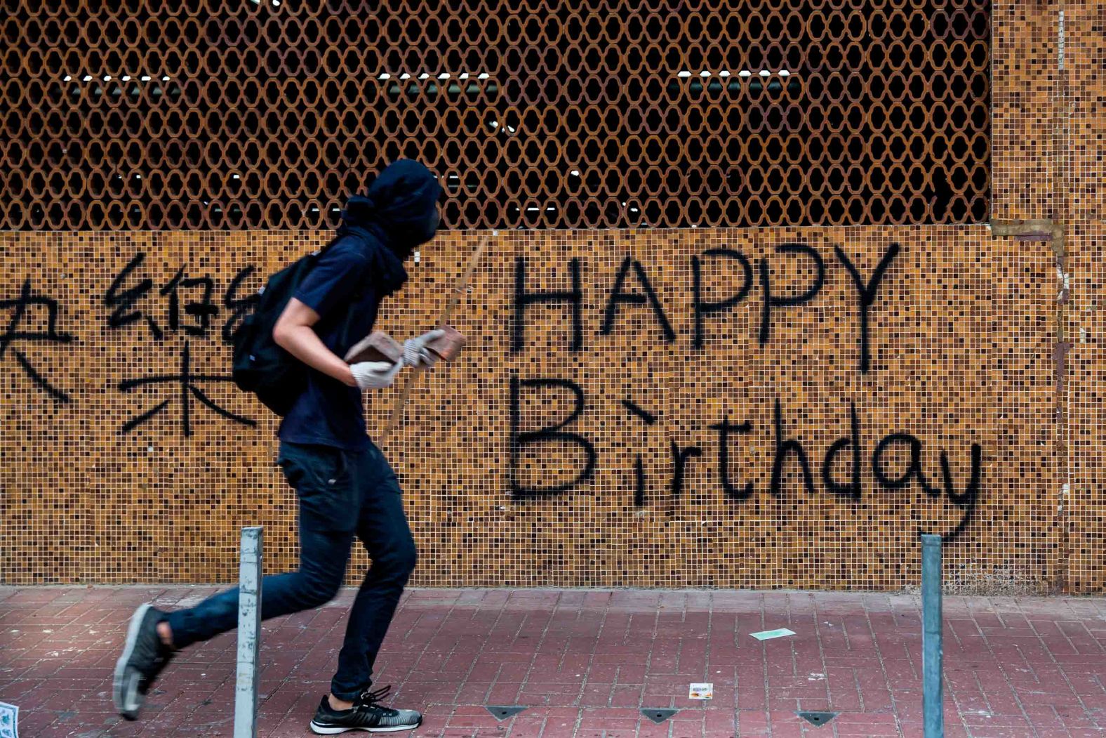 A protester is seen carrying rocks on a street on October 1. While events in Beijing were being held to mark the <a href="index.php?page=&url=https%3A%2F%2Fedition.cnn.com%2F2019%2F10%2F01%2Fworld%2Fgallery%2Fchina-70th-anniversary%2Findex.html" target="_blank">70th anniversary of the founding of the People's Republic of China,</a> demonstrators rallied throughout Hong Kong.