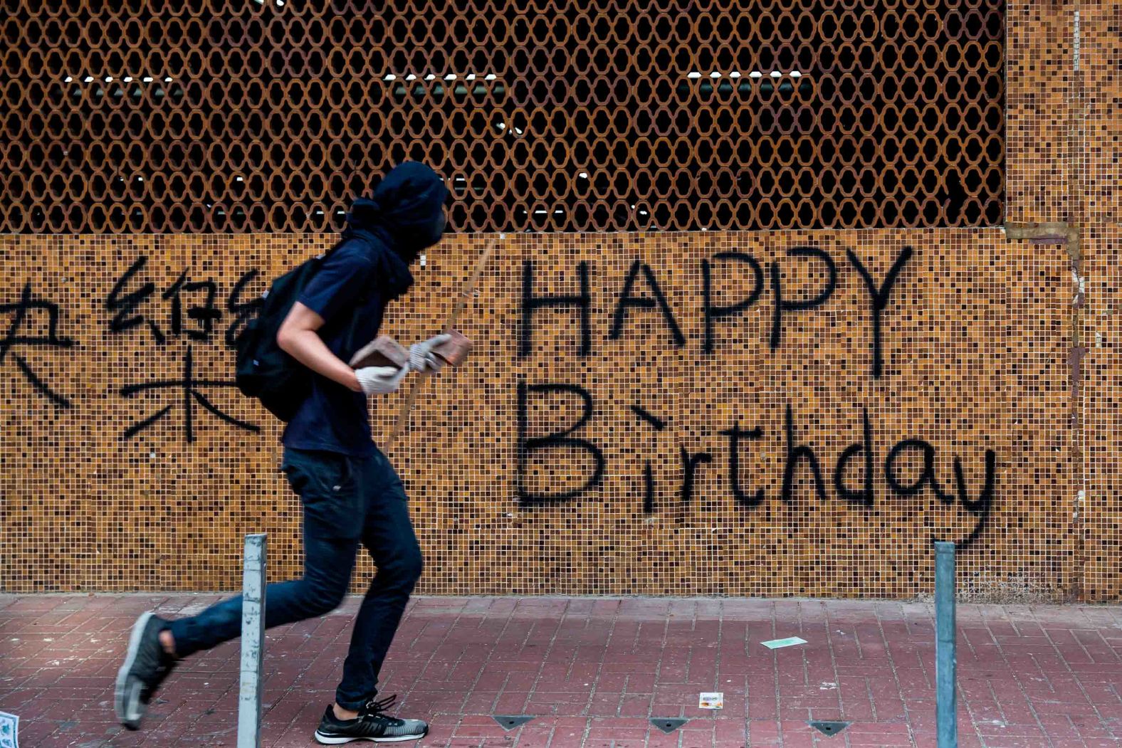 A protester is seen carrying rocks on a street on October 1. While events in Beijing were being held to mark the <a href="https://edition.cnn.com/2019/10/01/world/gallery/china-70th-anniversary/index.html" target="_blank">70th anniversary of the founding of the People's Republic of China,</a> demonstrators rallied throughout Hong Kong.