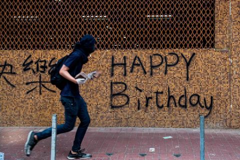 A protester is seen carrying rocks on a street on October 1. While events in Beijing were being held to mark the <a href=