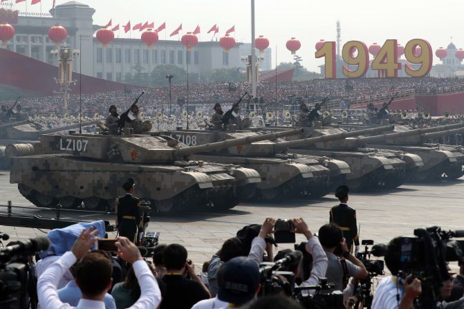 Army vehicles parade as members of a Chinese military honor guard march during the 70th anniversary celebrations in Beijing.