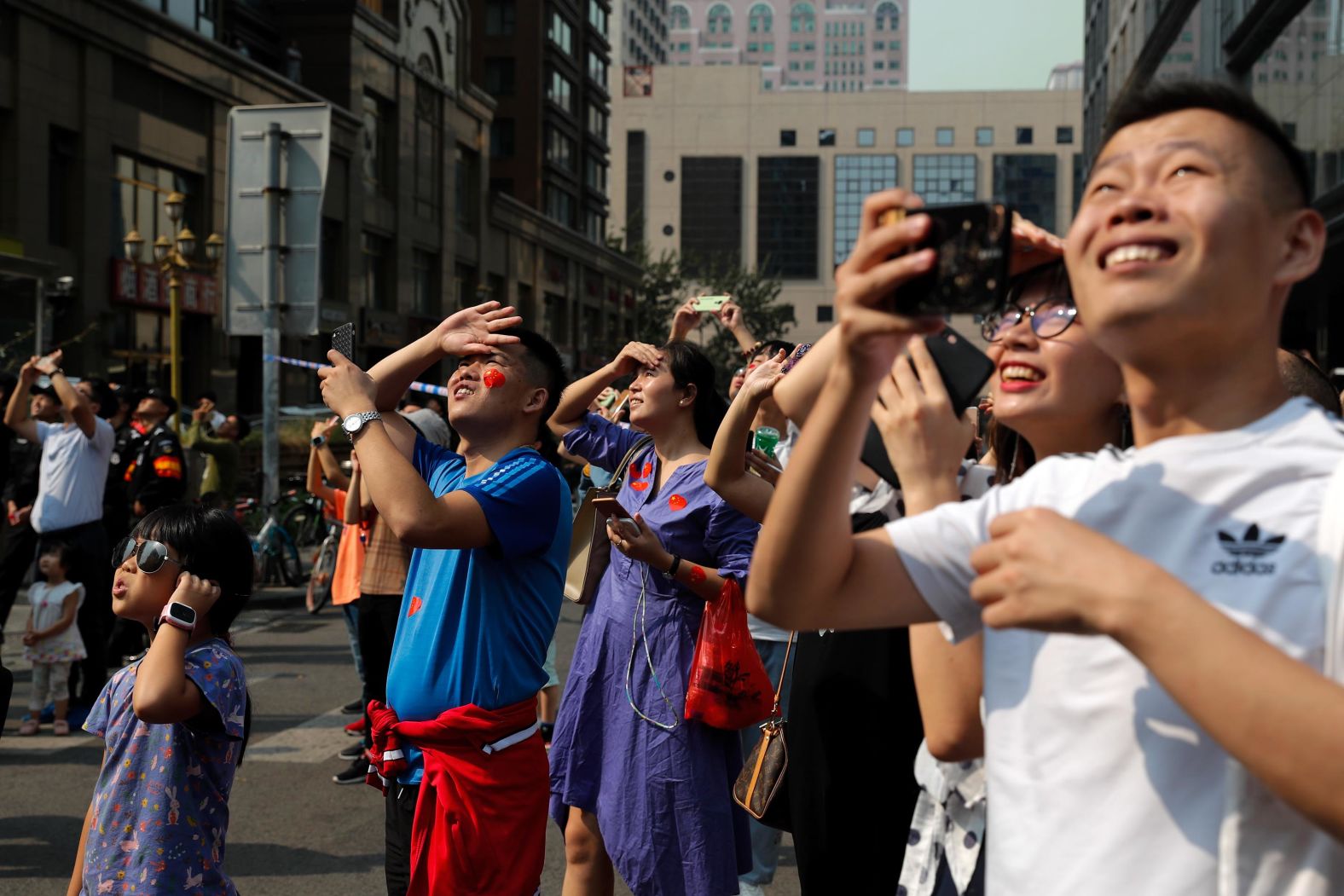 Residents watch Chinese military planes fly in formation above the capital city.