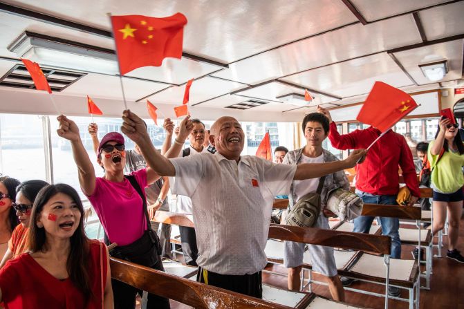 Pro-Beijing supporters wave Chinese flags on the Star Ferry in Hong Kong.