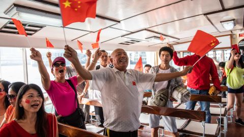 Pro-Beijing supporters wave Chinese flags on the Star Ferry in Hong Kong.