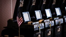 An American flag is displayed next voting machines at a polling station in Doral, Florida, U.S., on Tuesday, Aug. 28, 2018. 