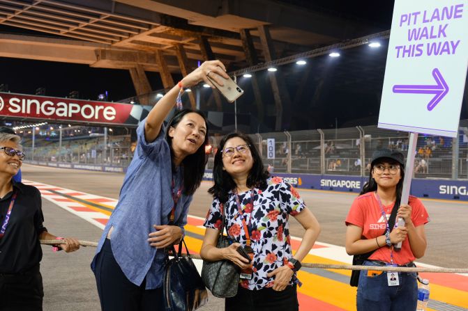 <strong>Touring the pit: </strong>Two Formula One fans take a selfie during the Paddock Club's pit lane experience, where visitors get a chance to photograph the racing car garages. 