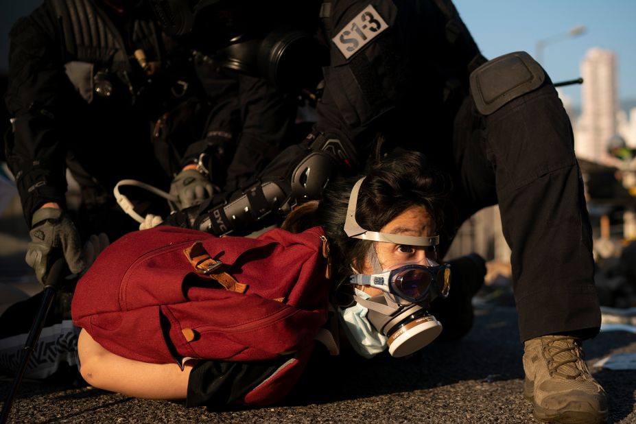 Police detain an anti-government protester on October 1. Thousands of black-clad protesters marched in central Hong Kong as part of multiple pro-democracy rallies.