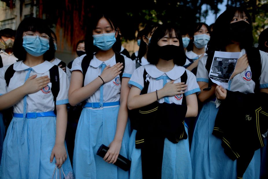 Schoolmates of a <a href="https://edition.cnn.com/2019/10/01/asia/hong-kong-oct-1-protests-escalation-intl-hnk/index.html" target="_blank">student who was shot in the chest by police</a> place their hands on their chests during a protest on October 2.