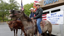 Cowboys carry the colors outside a venue in Omaha, Nebraska, October 2, where a meeting and rally is being held to urge President Trump and U.S. Department of Agriculture Secretary Perdue to ensure fair prices for cattle farmers and ranchers. 