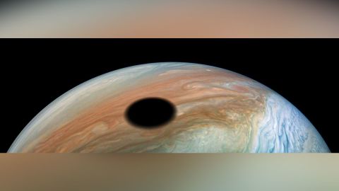 Jupiter's volcanically active moon Io casts its shadow on the planet.