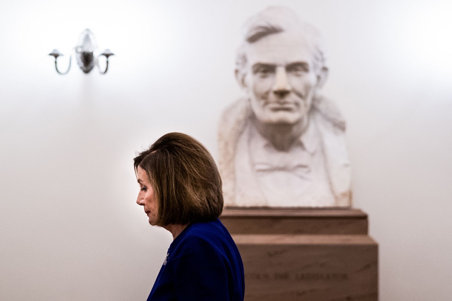 Pelosi walks past a bust of former President Abraham Lincoln on her way to her office on September 24.