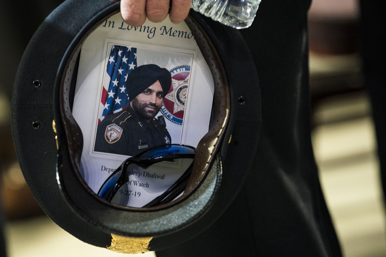 A picture of Dhaliwal is seen inside the hat of a Houston police officer during the funeral.