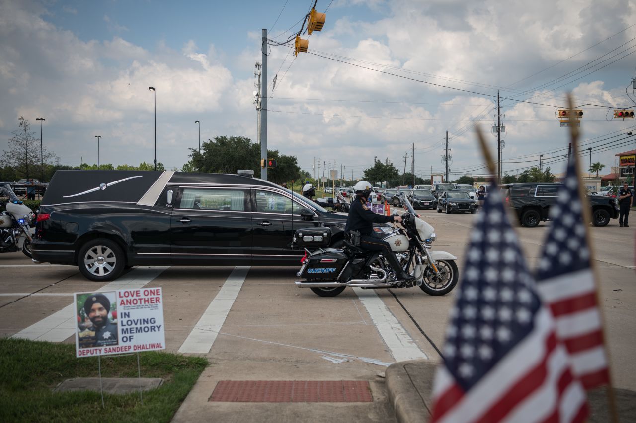 A hearse carrying Dhaliwal's casket departs following funeral services.