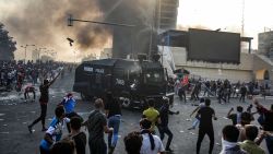 Protesters clash with an Iraqi riot police vehicle during a demonstration against state corruption and poor services, between the capital Baghdad's Tahrir Square and the high-security Green Zone district, on October 1, 2019. - Security forces used water cannons and tear gas to disperse more than 1,000 protesters in central Baghdad. Iraq is considered the 12th most corrupt country in the world according to Transparency International. Power cuts are rampant, water shortages are common and unemployment is high, particularly among youth. (Photo by AHMAD AL-RUBAYE / AFP)        (Photo credit should read AHMAD AL-RUBAYE/AFP/Getty Images)