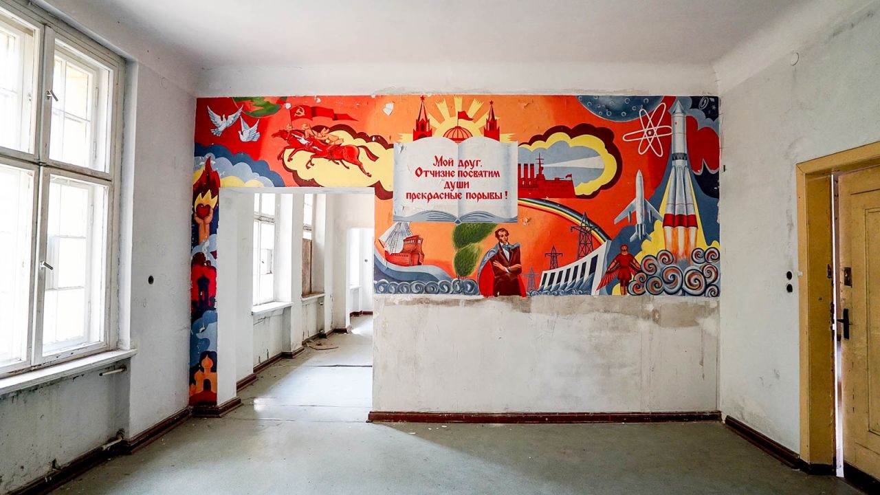 A brilliant painted mural of communist heroes inside the empty building.