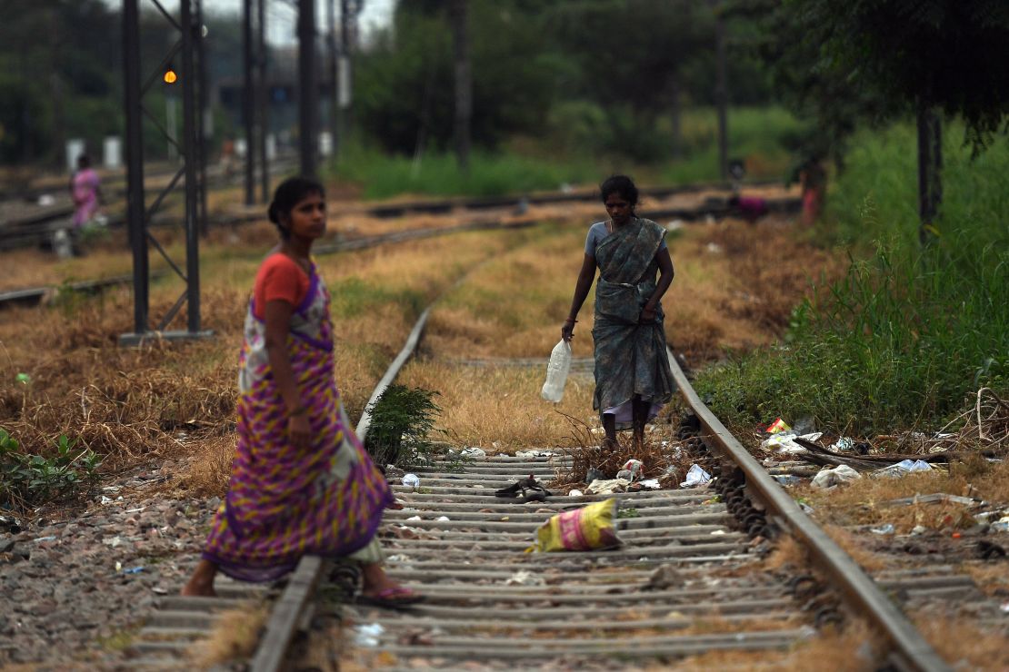 Women walking on train tracks in an area where people defecate in the open near Nizamuddin railway station in New Delhi on September 27, 2019.
