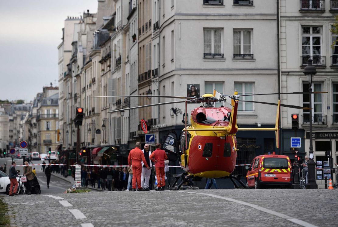Emergency personnel stand by an air ambulance helicopter on the Pont Marie near Paris police HQ.