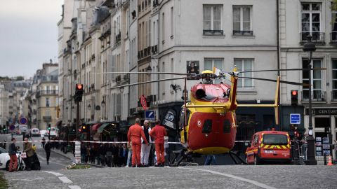 Emergency personnel stand by an air ambulance helicopter on the Pont Marie near Paris police HQ.