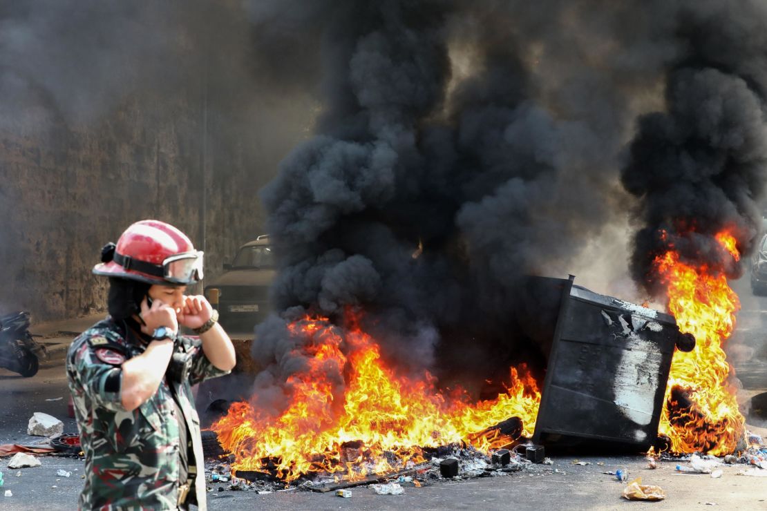 A Lebanese firefighter walks past a burning dumpster during a demonstration in central Beirut's Martyr Square on September 29.