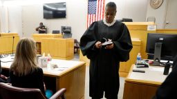 State District Judge Tammy Kemp opens a Bible to John 3:16 before giving it to former Dallas Police Officer Amber Guyger, left, before Guyger left for jail, Wednesday, Oct. 2, 2019, in Dallas. Guyger, who said she mistook neighbor Botham Jean's apartment for her own and fatally shot him in his living room, was sentenced to a decade in prison. (Tom Fox/The Dallas Morning News via AP, Pool)