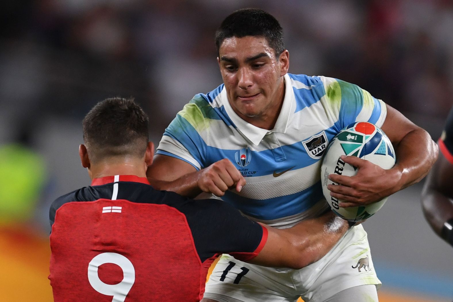 Argentina's wing Santiago Carreras runs into England's scrum-half Ben Youngs at the Tokyo Stadium.