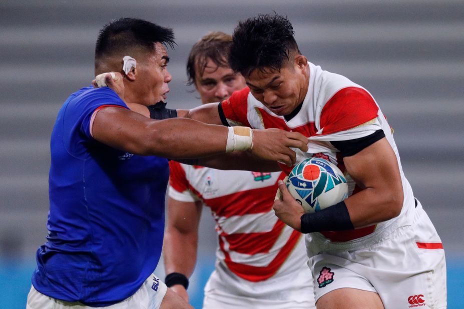 Japan's number 8 Kazuki Himeno (R) is tackled by Samoa's prop Michael Alaalatoa (L)  during a hard-fought encounter at the City of Toyota Stadium.