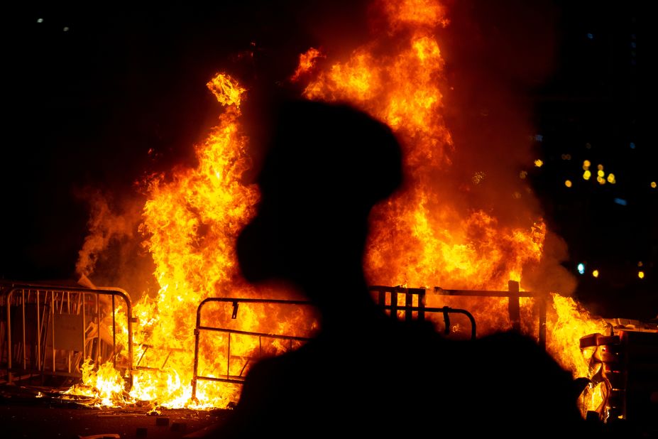 An anti-government protester stands near a fire on Friday, October 4.