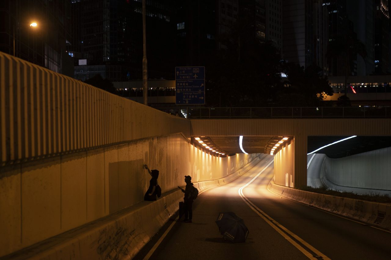 Protesters spray paint slogans at the entrance to a tunnel on October 4.