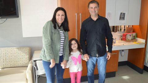 Sophia is seen here, smiling with her parents.