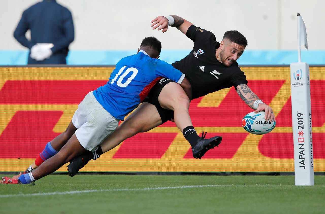 New Zealand's T J Perenara is about to score a try as he is tackled by Namibia's Helarius Kisting.
