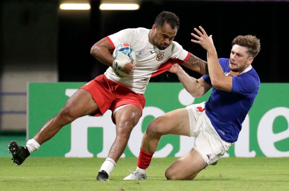 Tonga's Atieli Pakalani, left, is tackled by a French defender at the Kumamoto Stadium.  