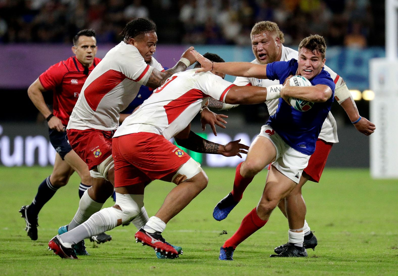 France's Antoine Dupont runs at the Tongan defense during a hard-fought encounter.