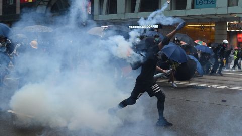 A protester throws back a teargas cannister towards police in the Wanchai district in Hong Kong on Sunday.