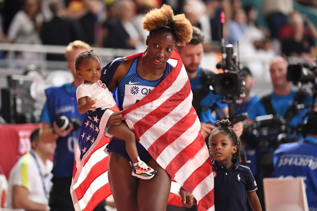 Nia Ali celebrates with her children Yuri (left) and Titus after winning gold in the 100m hurdles in Doha.