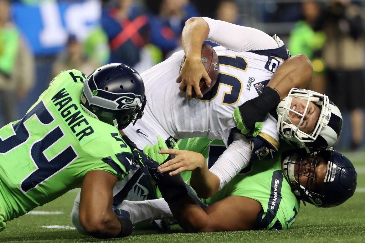 Los Angeles Rams quarterback Jared Goff is tackled by Seattle's Bobby Wagner and Al Woods during an NFL game on Thursday, October 3.