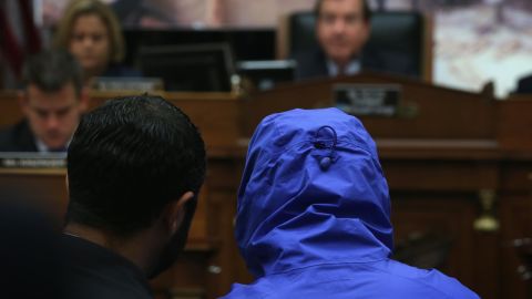 Syrian defector Caesar conceals his identity as he listens with a translator to the House Foreign Affairs Committee in 2014.