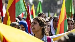 Syrian Kurdish women carry flags and banners as they demonstrate against Turkish threats to launch a military operation on their region in northeastern Syrian on October 7, 2019.