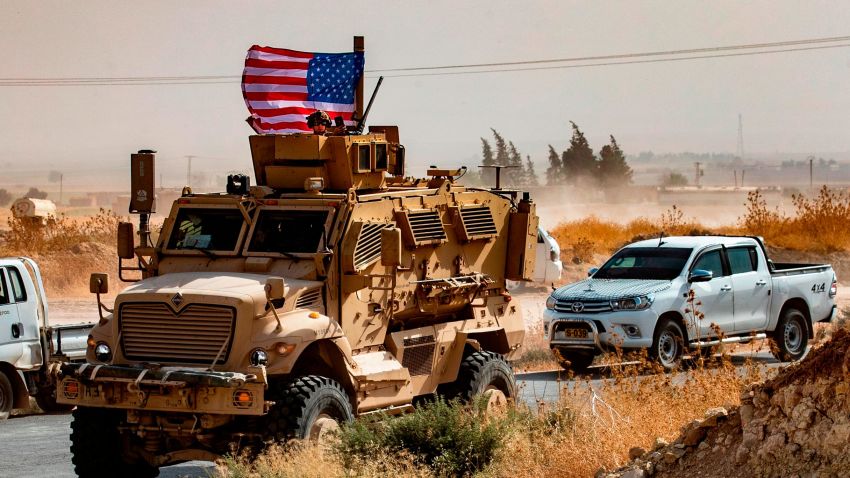 A US soldier sits atop an armoured vehicle during a demonstration by Syrian Kurds against Turkish threats next to a base for the US-led international coalition on the outskirts of Ras al-Ain town in Syria's Hasakeh province near the Turkish border on October 6, 2019. - US forces in Syria started pulling back today from Turkish border areas, opening the way for Ankara's threatened military invasion and heightening fears of a jihadist resurgence. (Photo by Delil SOULEIMAN / AFP) (Photo by DELIL SOULEIMAN/AFP via Getty Images)