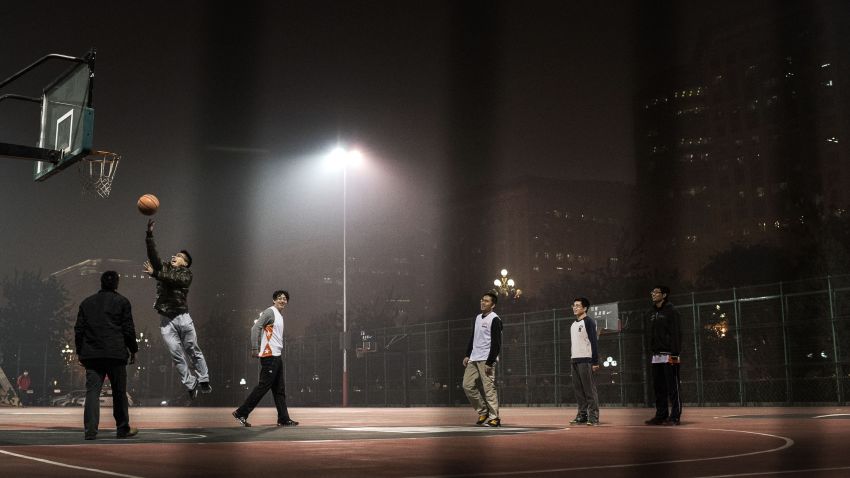 BEIJING, CHINA - NOVEMBER 26:  Chinese men play a game of pick-up basketball on an outdoor court in smoggy weather on November 26, 2014 in Beijing, China.United States President Barack Obama and China's president Xi Jinping agreed on a plan to limit carbon emissions by their countries, which are the world's two biggest polluters, at a summit in Beijing earlier this month.  (Photo by Kevin Frayer/Getty Images)