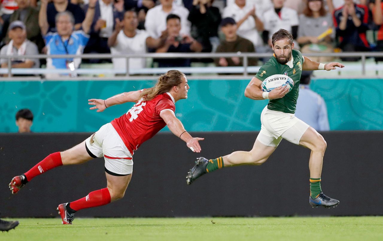 South Africa's Cobus Reinach runs clear of Canada's Jeff Hassler during the Pool B game at Kobe Misaki Stadium. 