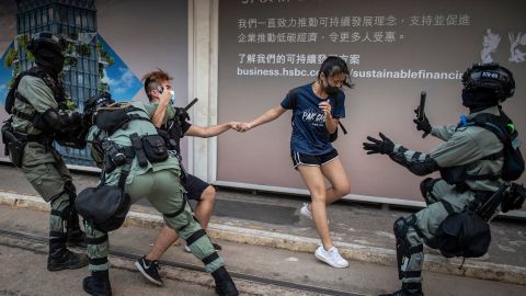 Police chase down a couple wearing facemasks in the central district in Hong Kong on October 5, 2019.