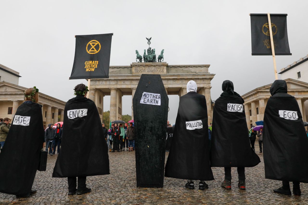 Protesters wearing black stand next to a coffin as they stage a demonstration in front of Berlin's Brandenburg Gate on October 8. 