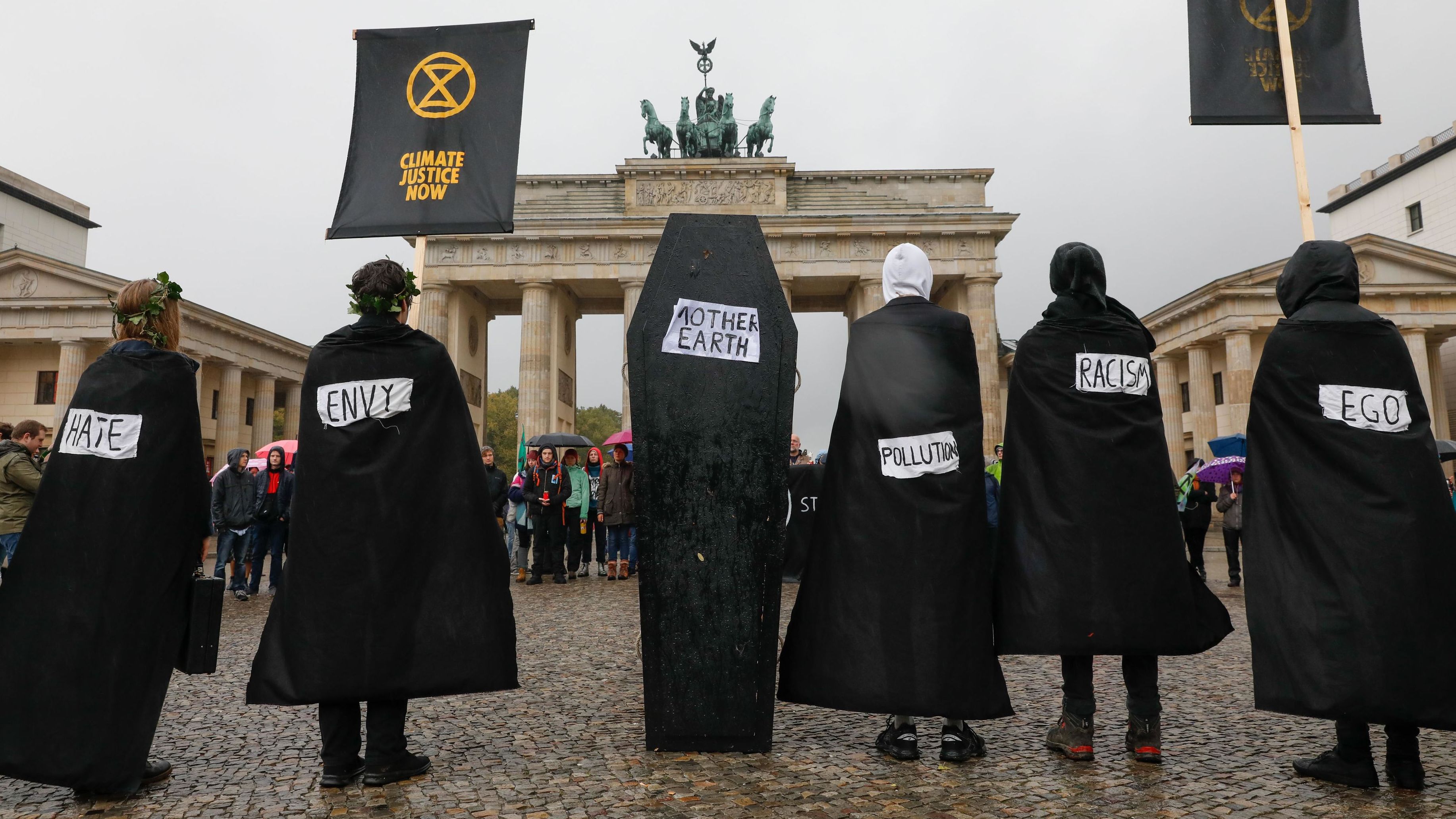 Protesters wearing black stand next to a coffin as they stage a demonstration in front of Berlin's Brandenburg Gate on October 8. 