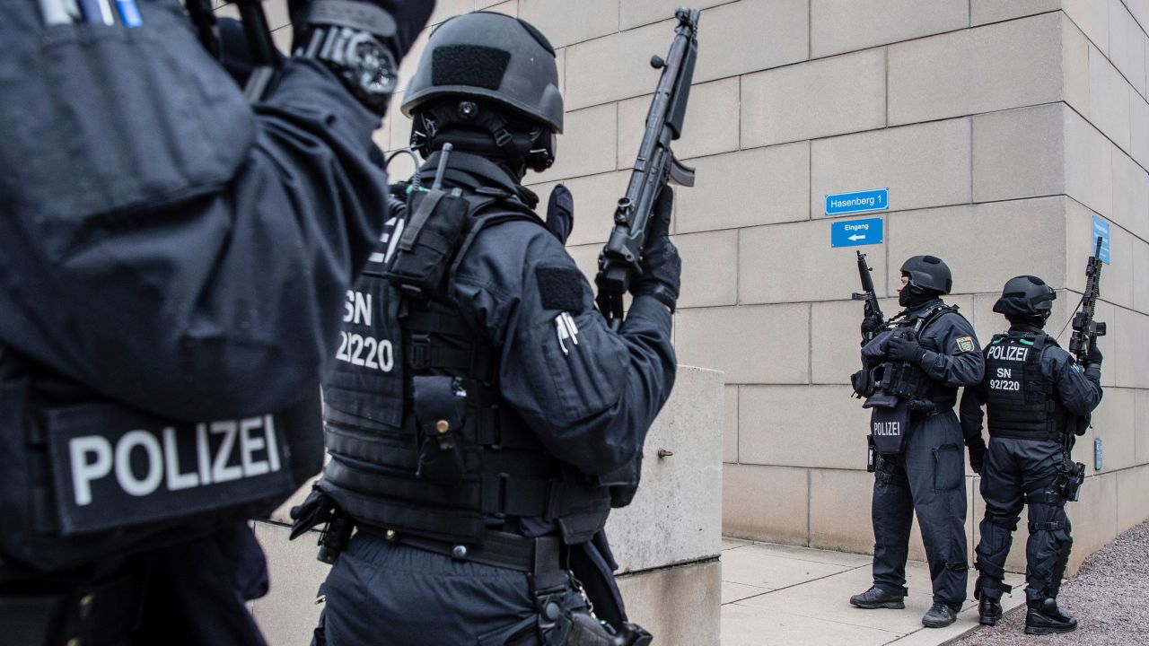 CORRECTS CITY TO DRESDEN -- Police officers secure a synagogue in Dresden, Germany, Wednesday, Oct. 9, 2019. One or more gunmen fired several shots on Wednesday in the German city of Halle. Police say a person has been arrested after a shooting that left two people dead. (Robert Michael/dpa via AP)