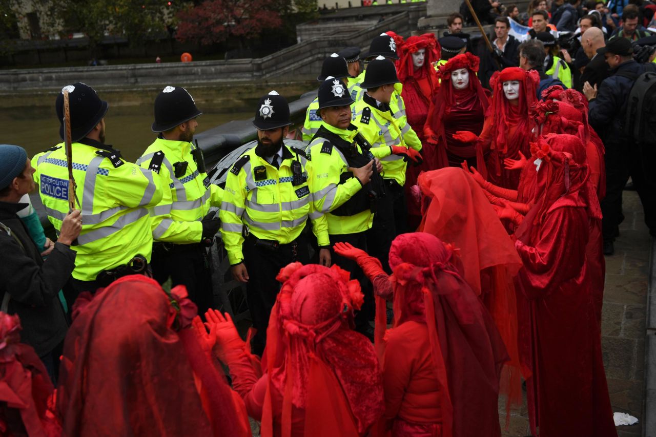 The Red Brigade surrounds police in London on October 7. This crimson-robed troupe is common at Extinction Rebellion protests and is the creation of the Invisible Circus, a street performance group.