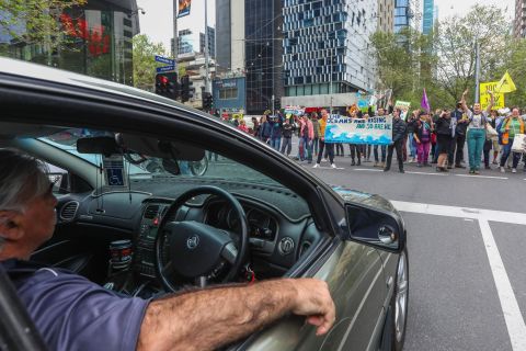 A driver watches protesters block a city intersection in Melbourne on October 7. 