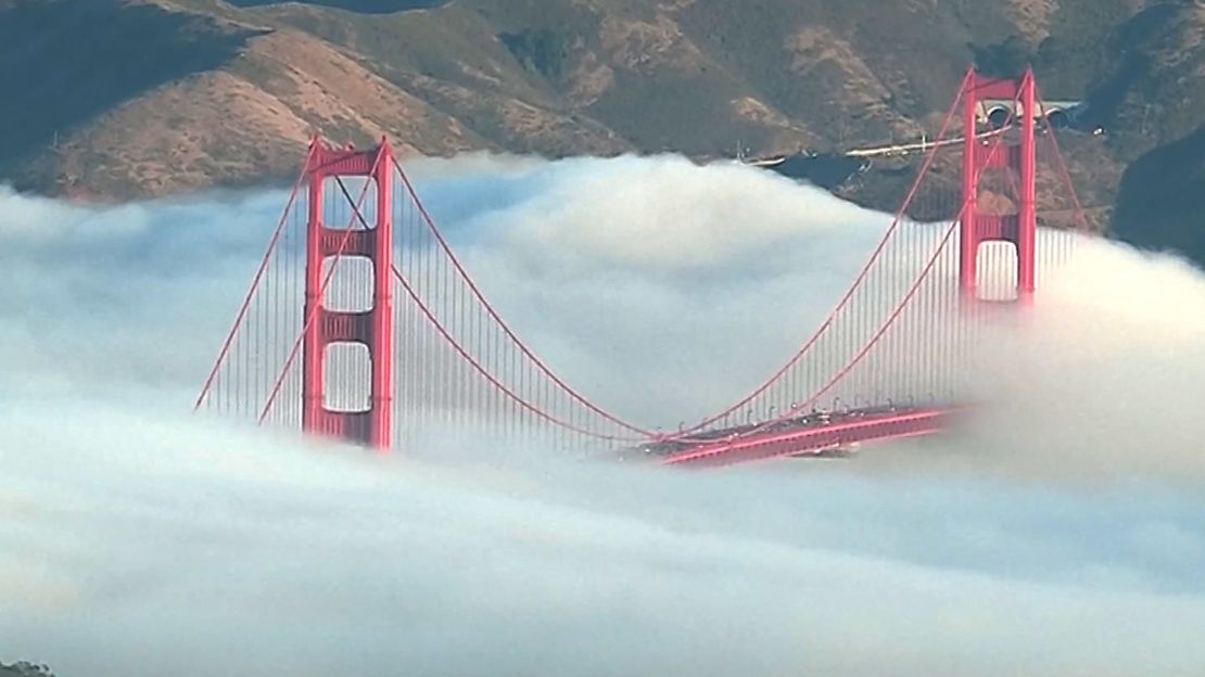 The top of the iconic Golden Gate Bridge pokes above a thick San Fransico fog.