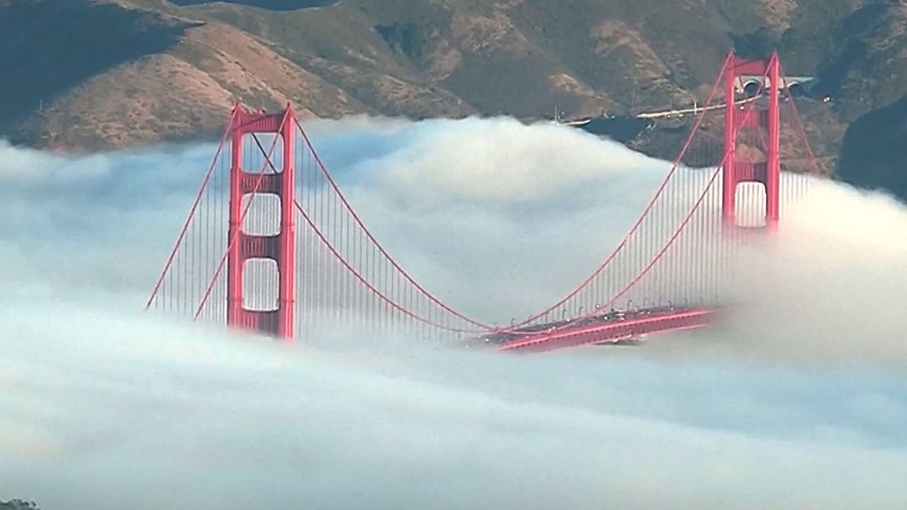 The top of the iconic Golden Gate Bridge pokes above a thick San Fransico fog.