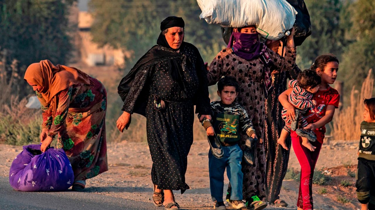 Civilians flee amid Turkish bombardment on Syria's northeastern town of Ras al-Ain in the Hasakeh province along the Turkish border on October 9, 2019.