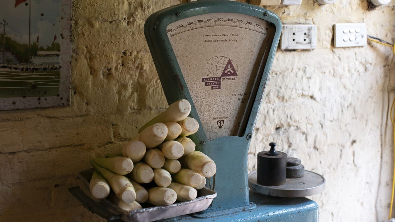 A large blue chipped scale piled high with root vegetables greets guests upon entry. 